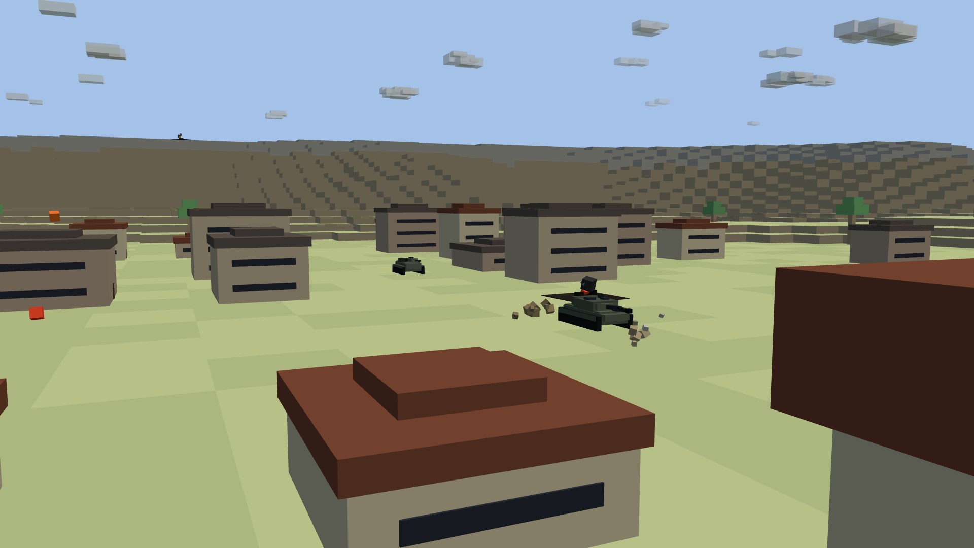 A tank and an infantry fighting vehicle pushing down a town's main street between blocky houses, dust rising off the lead tank's treads